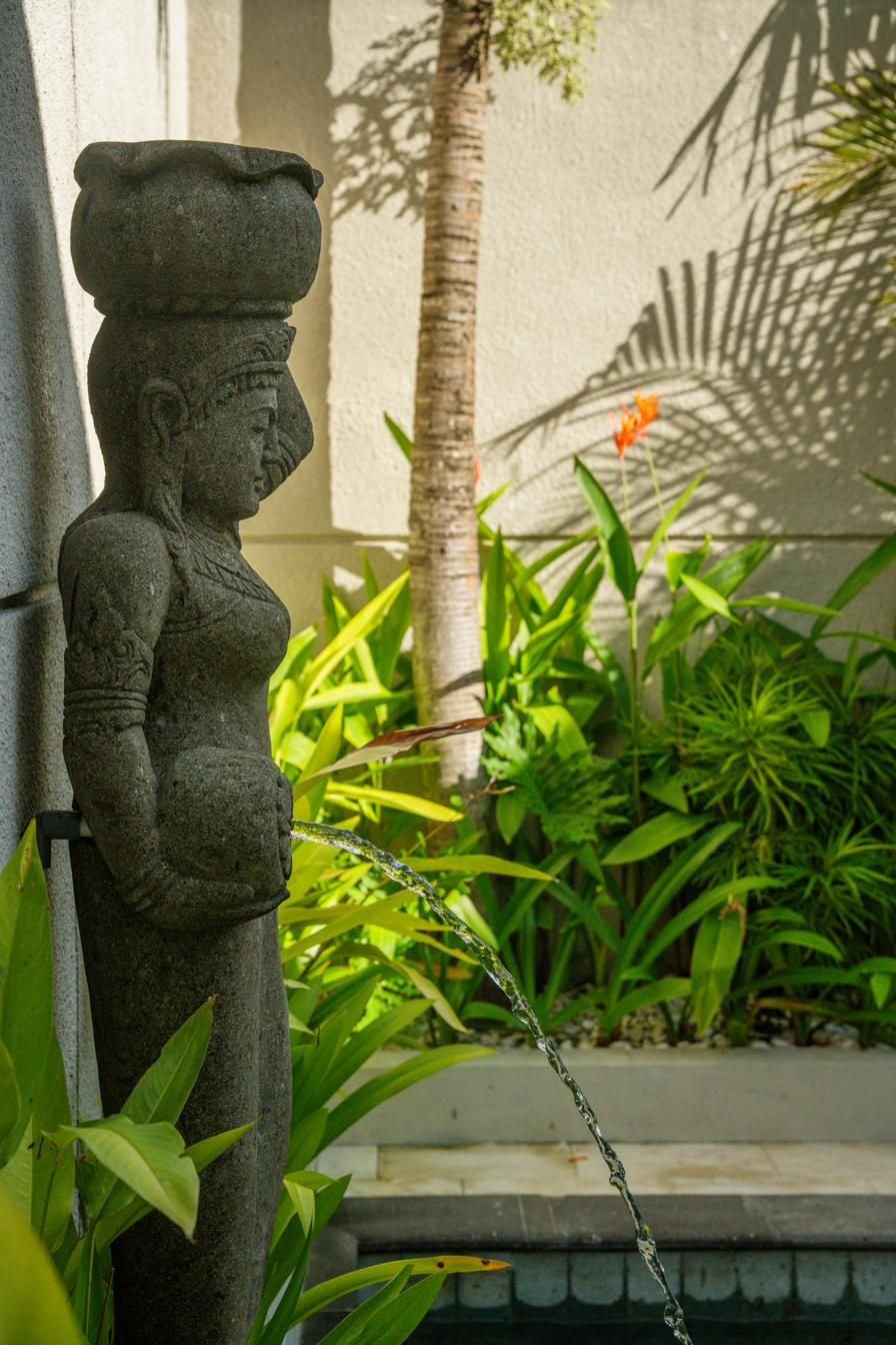 Stone fountain statue by the pool